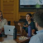 A diverse group of professionals collaborating around a table with laptops, emphasizing teamwork and strategic planning for corporate events.